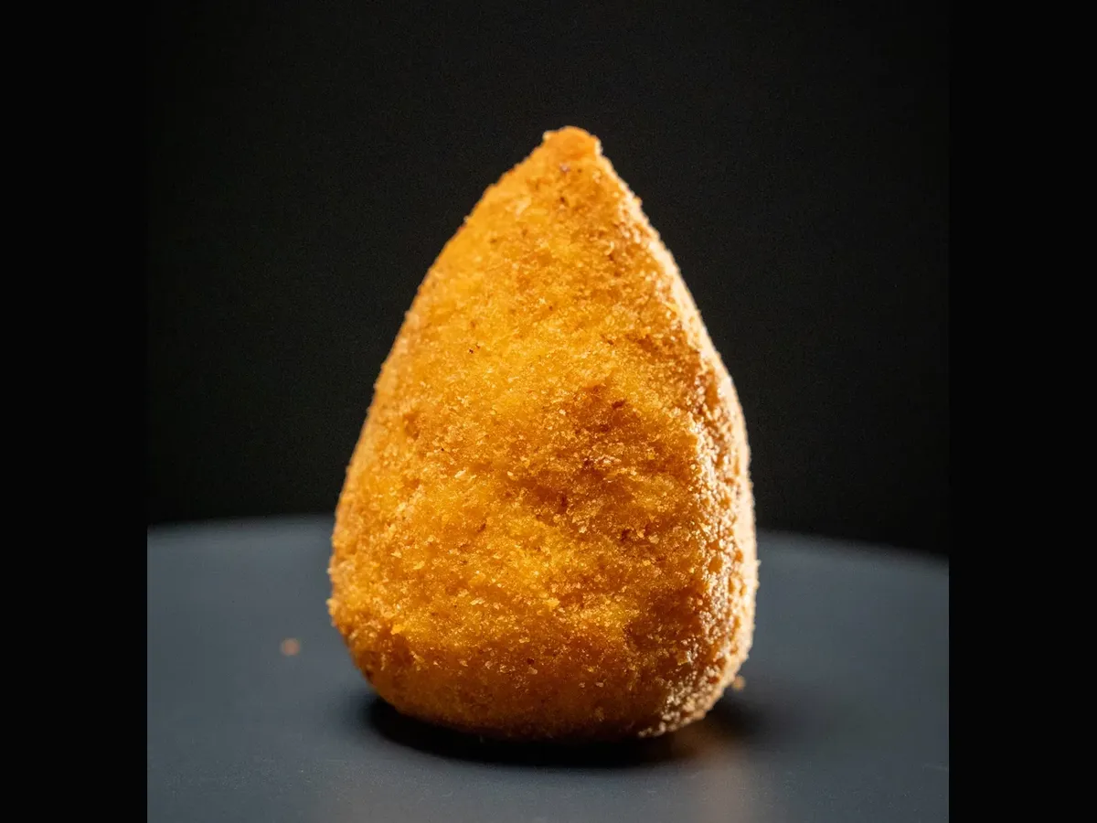 Sicilian arancino — cone-shaped breaded and fried rice ball, golden and crispy